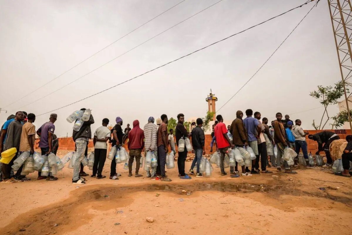Migrants queing for water